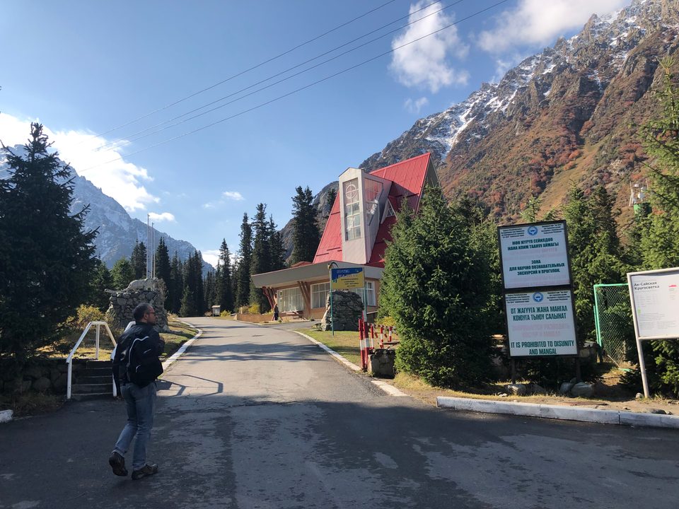 Entrance arch of Ala-Archa National Park with mountains behind it.