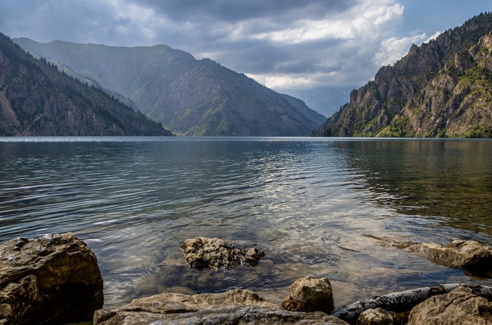 Вид на Сары-Челек с зелёными склонами у воды.
